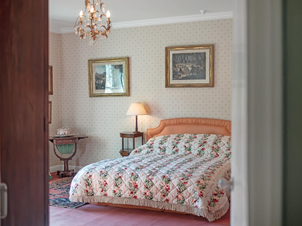 Principal bedroom with chandelier and period decor at Loddon Hall, Norfolk