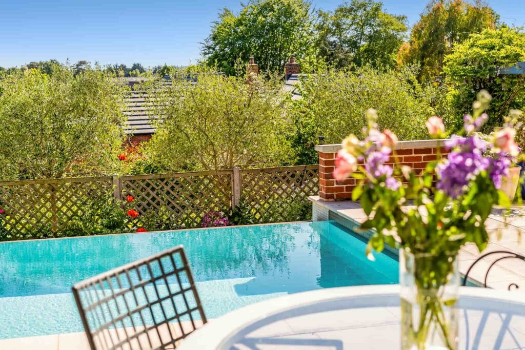 Poolside view with sparkling water framed by lush greenery.