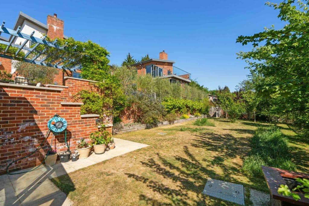 Tiered garden with brick terraces, pergola, and mature planting.