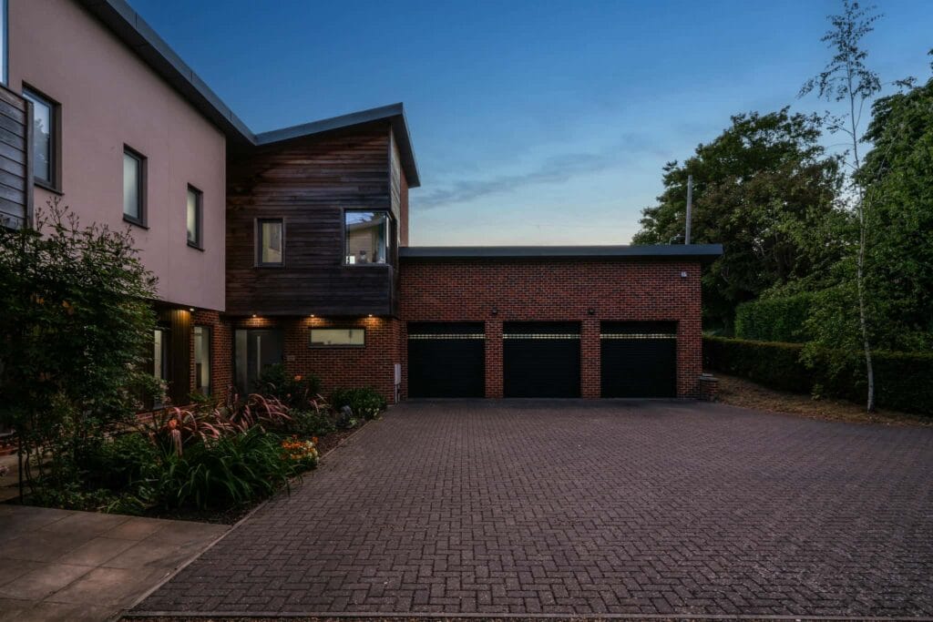 Grand driveway arrival framed by soft evening light, setting a tranquil and inviting tone for the home.