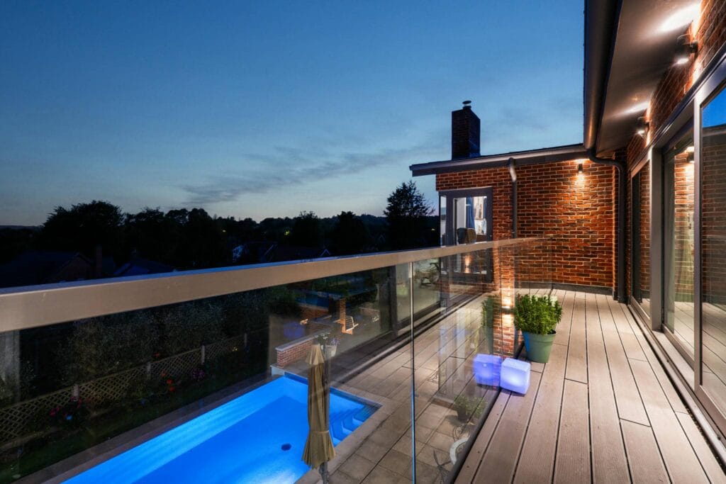 Elegant balcony with a serene pool view, perfect for unwinding under the evening sky.