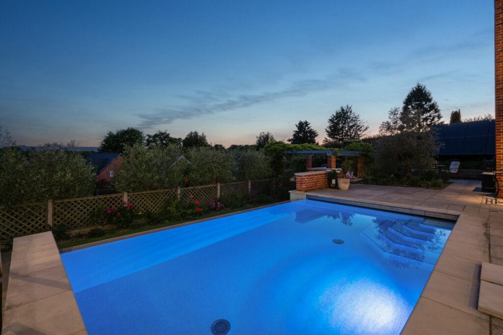 Tranquil infinity pool glowing at dusk, offering a serene backdrop for evening swims and sunset views.