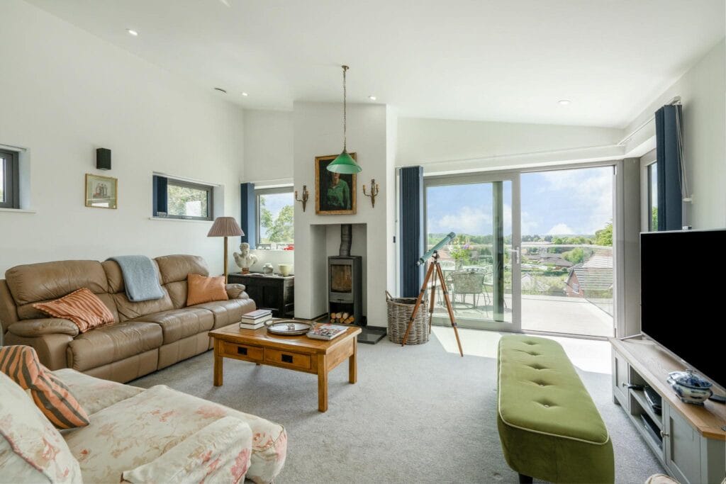 Bright upstairs living room with balcony access and scenic views.