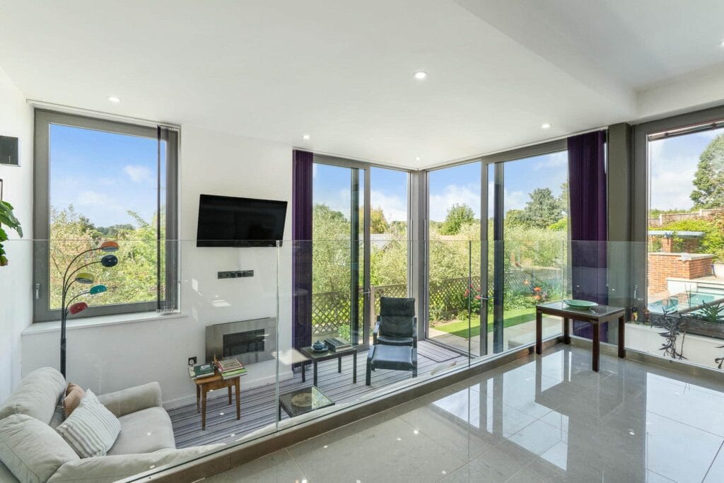 Bright kitchen dining space flowing into a cosy snug with garden views and terrace access.