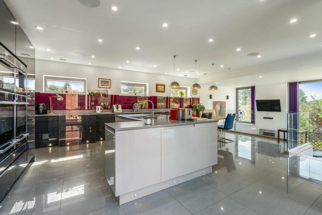 Sleek designer kitchen with expansive island, premium appliances, and vibrant finishes perfect for cooking and entertaining.