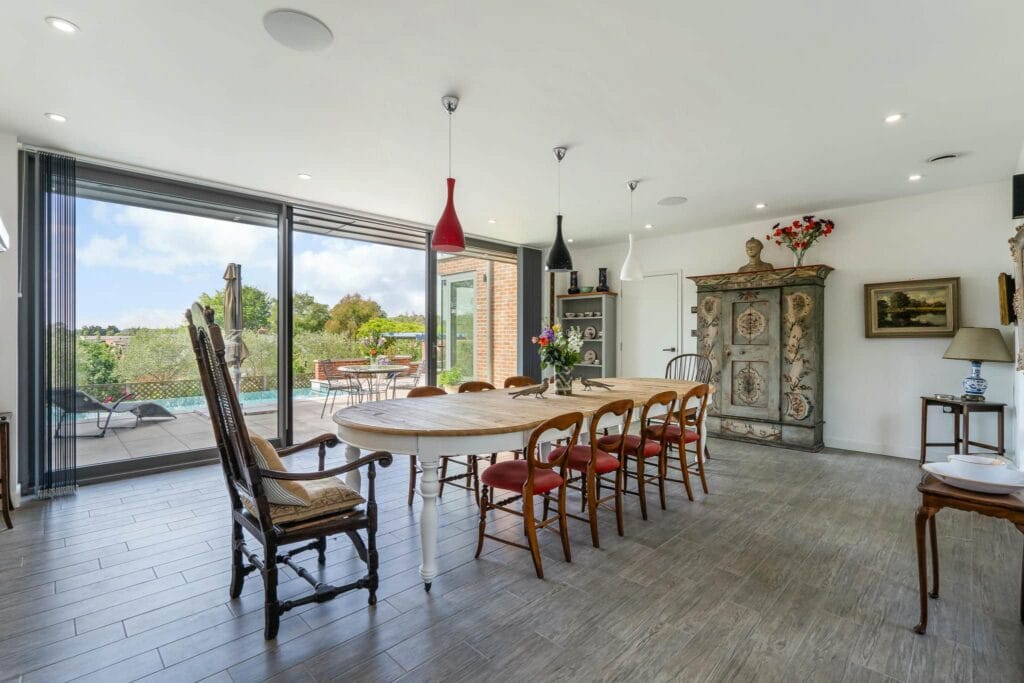 Elegant dining room with panoramic patio and pool views, perfect for hosting memorable gatherings in style.