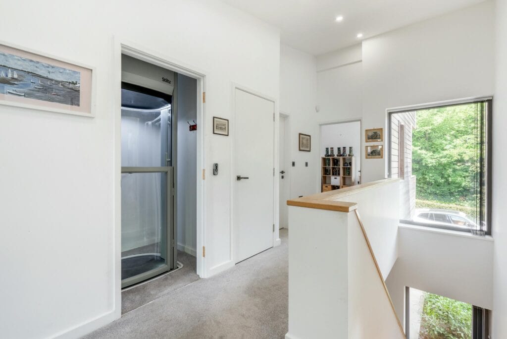 Bright upstairs landing featuring a modern home lift to the ground floor, blending convenience with contemporary design.