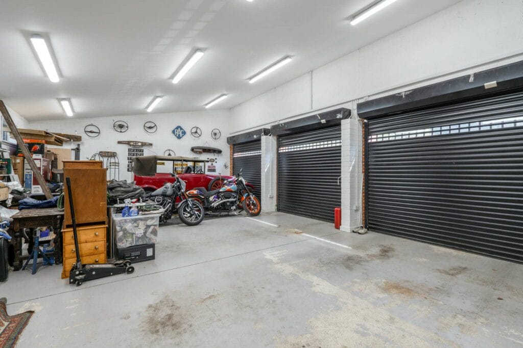 Spacious triple garage, brightly lit and ideal for vehicles, storage, or a workshop.