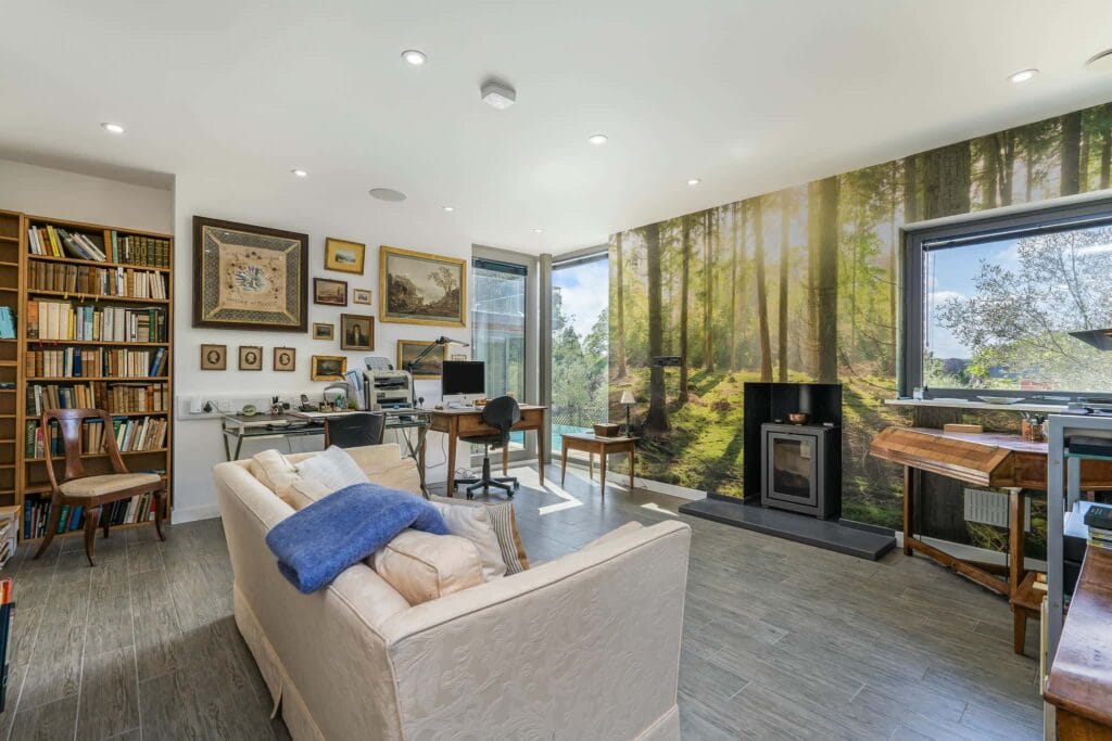 Versatile ground-floor office or bedroom with pool views and wood-burning stove.
