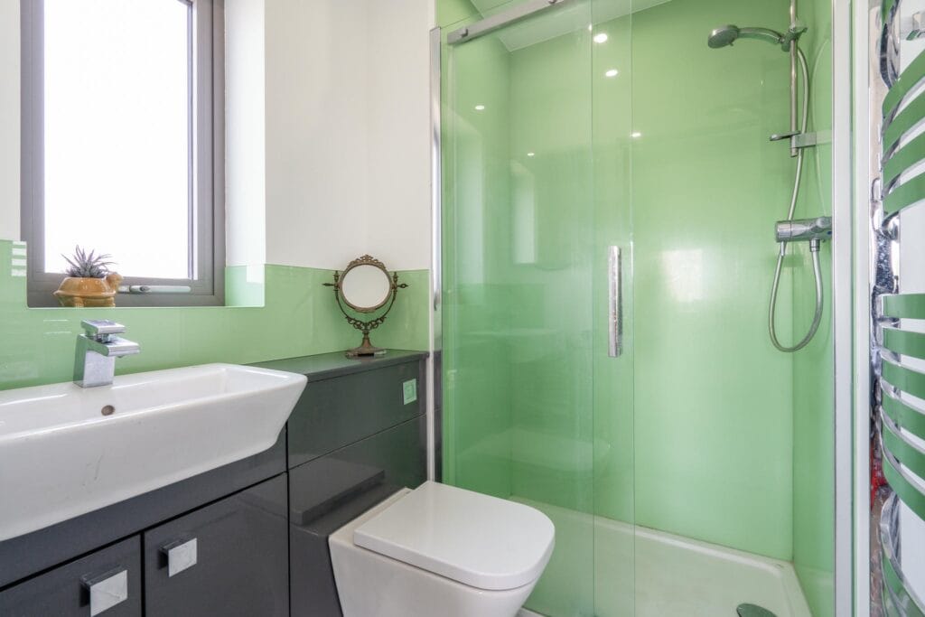 Guest shower room with fresh green accents and modern fittings.