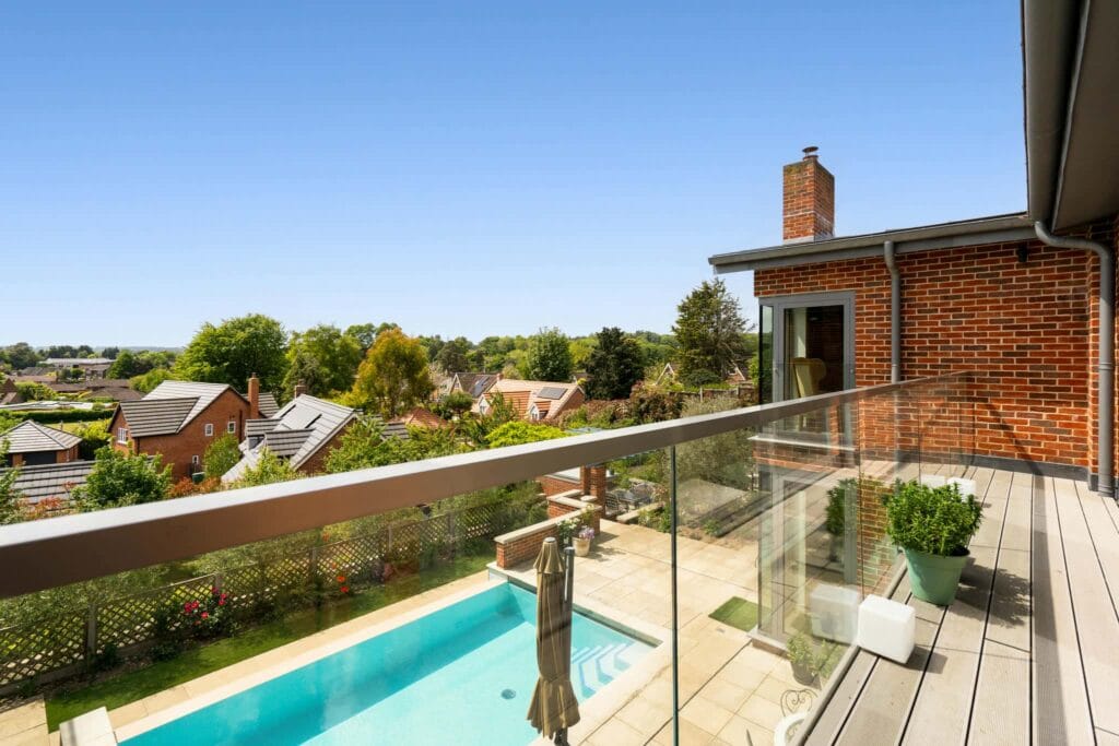 Balcony from the principal bedroom with sweeping views over the pool, gardens, and rooftops.