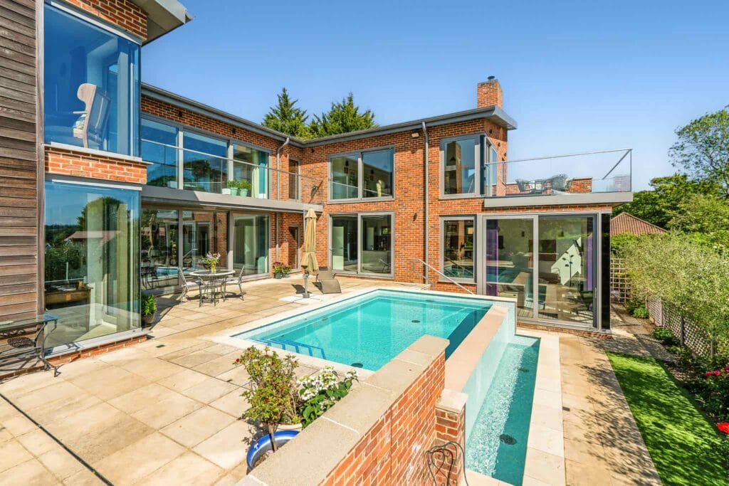 Modern courtyard pool surrounded by glass-fronted living spaces.