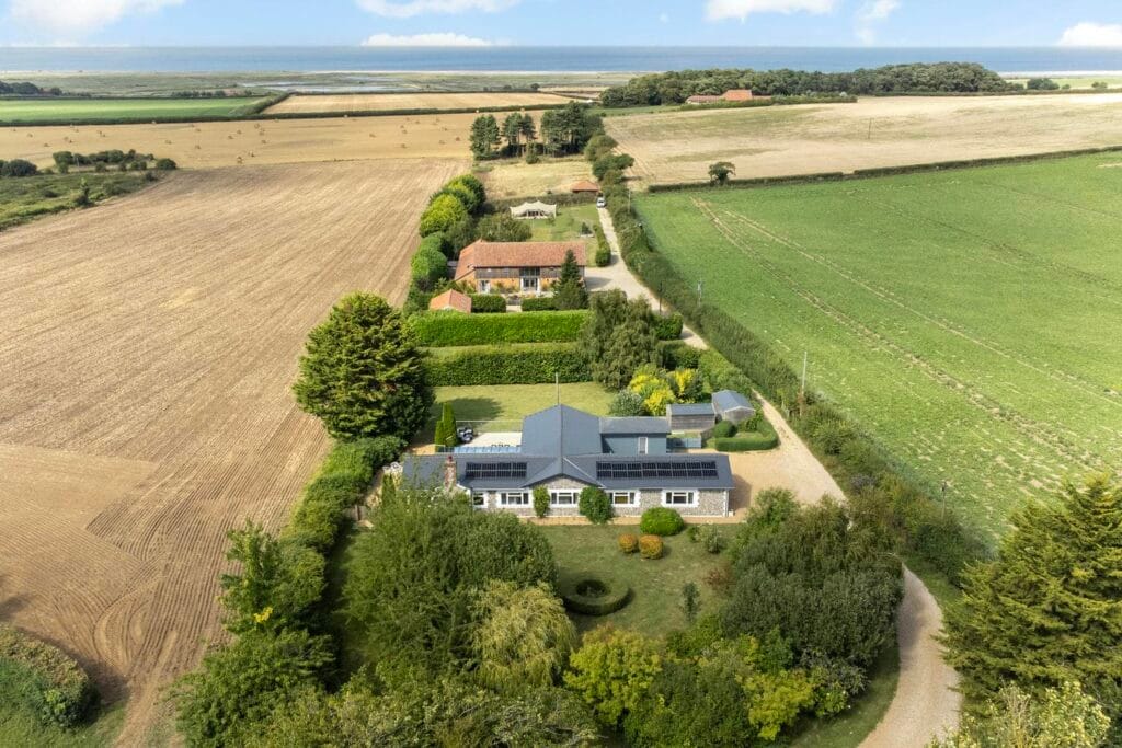 Sweeping aerial view of Rectory Hill Cottage with coastal backdrop