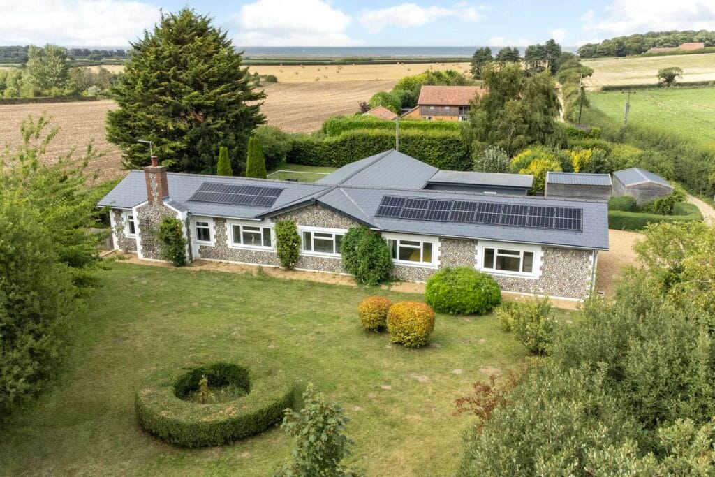 Front elevation of Rectory Hill Cottage with flint façade and solar panels