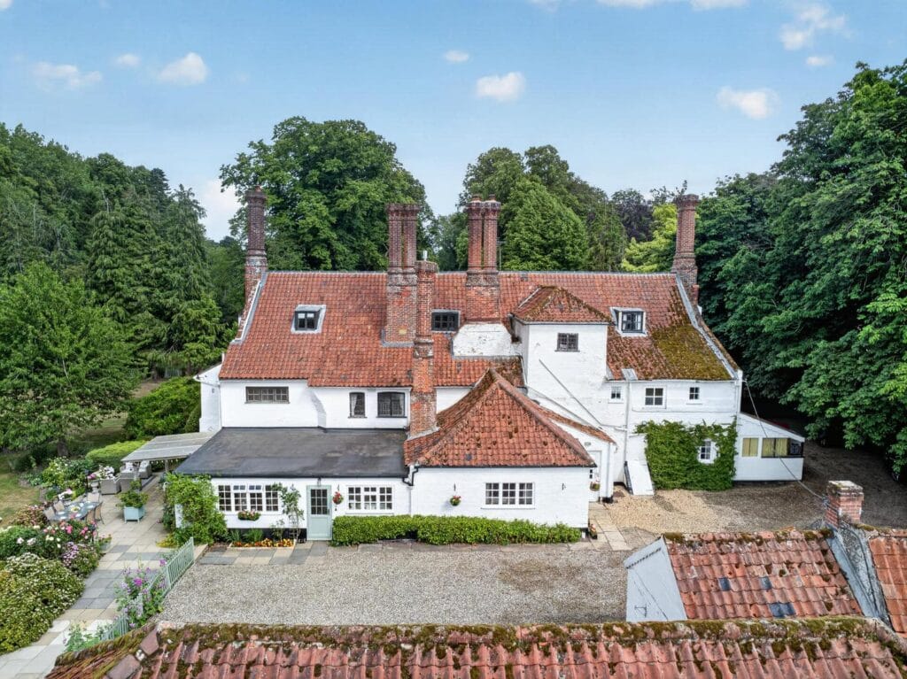 Aerial rear view of Ashill country house with outbuildings and woodland