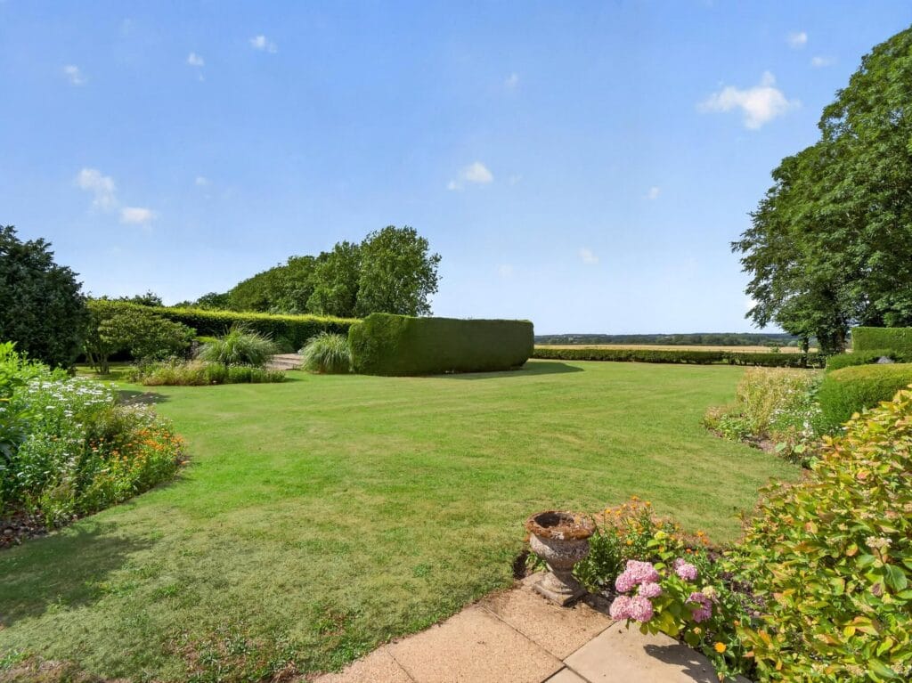 Formal garden with manicured lawn, borders and open Norfolk countryside