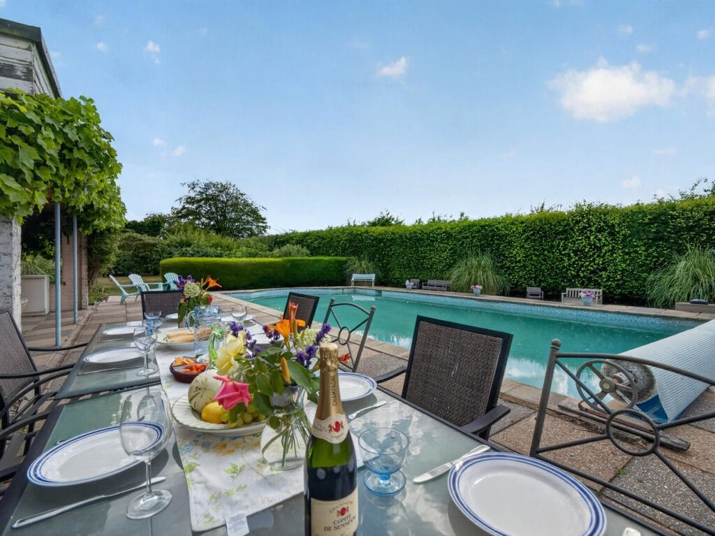 Al fresco dining table set for entertaining beside the outdoor pool