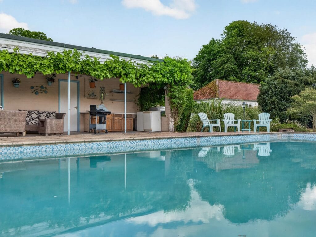 Heated outdoor pool and pool house with seating area Norfolk