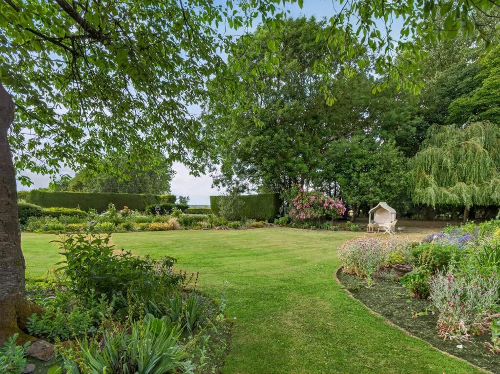 Bury's Hall Ashill landscaped garden with mature trees and borders