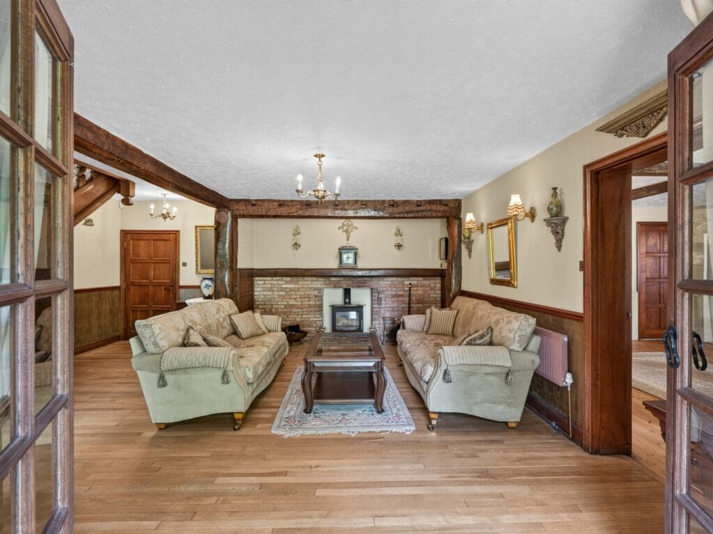 Elegant sitting room with wood burner, beams and oak panelling