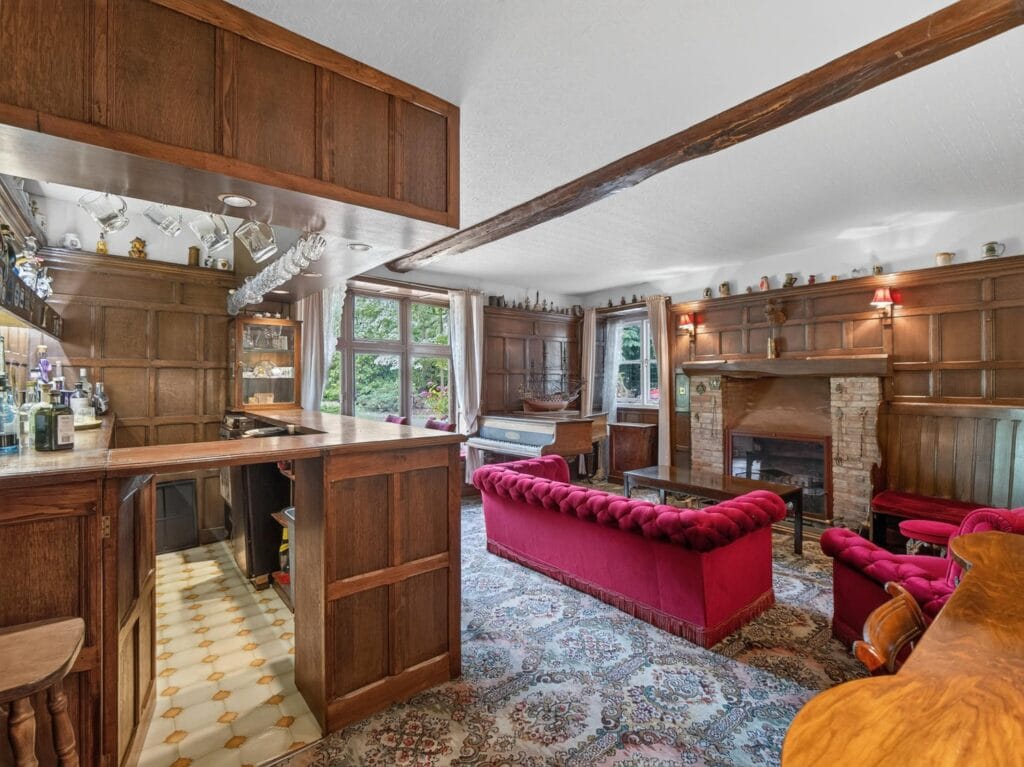 Characterful games room with bar, panelling and open fireplace