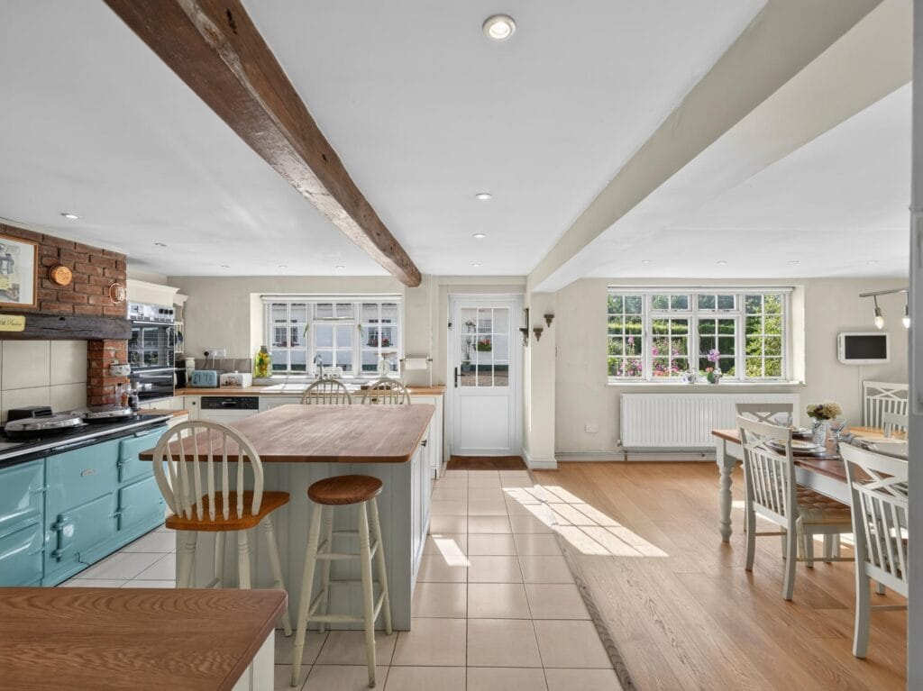 Spacious kitchen with teal Aga and central island at Bury's Hall