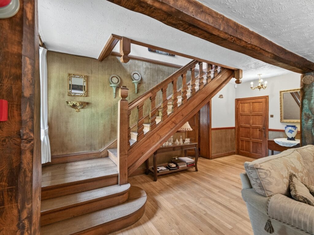 Elegant oak staircase with turned spindles and beamed hallway