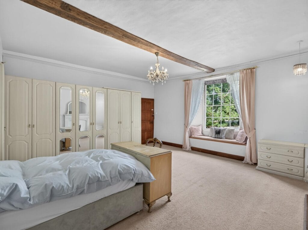 Spacious bedroom with built-in wardrobes and window seat at Bury's Hall