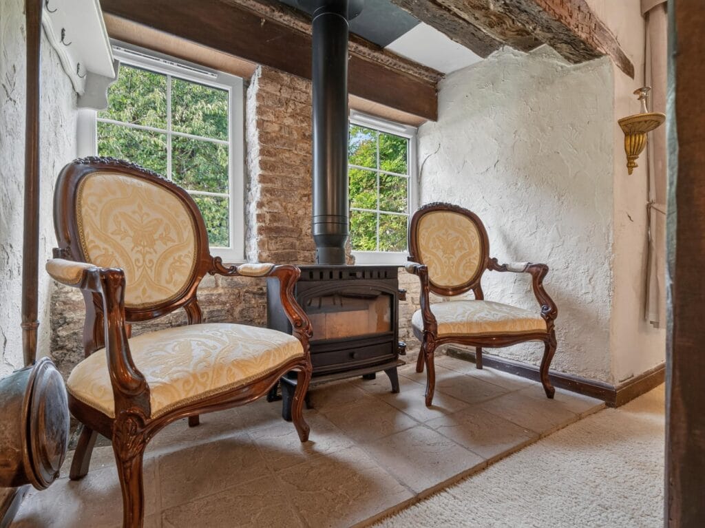 Characterful sitting area with cast iron stove and antique chairs