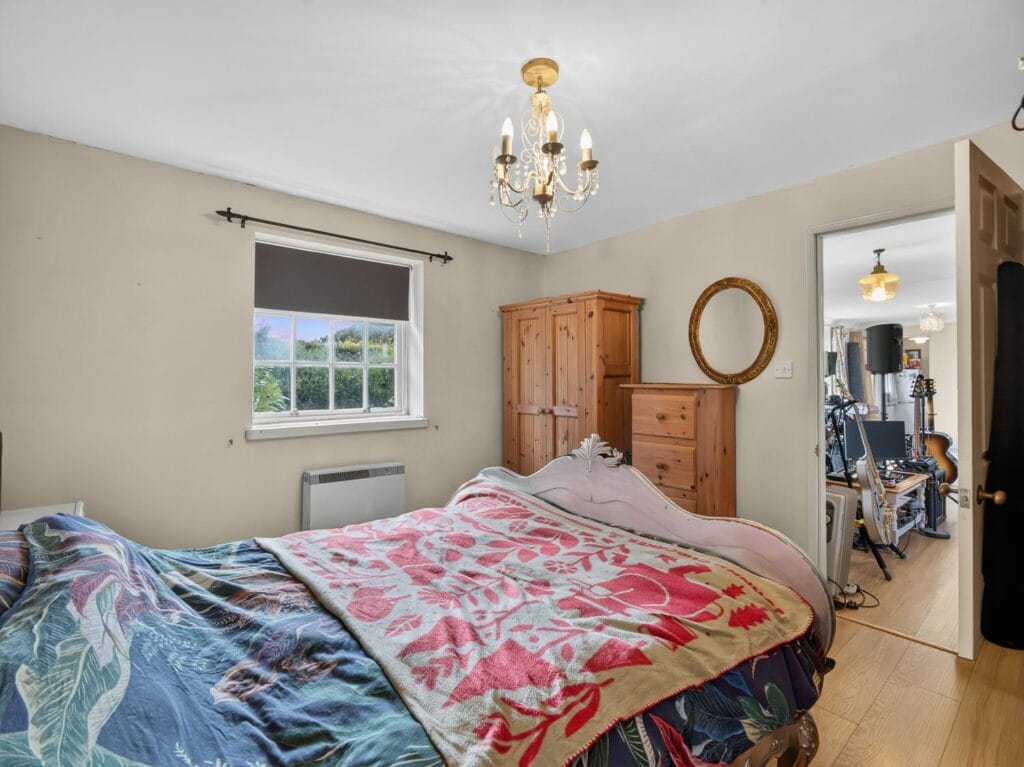 Double bedroom with chandelier, pine wardrobe and garden views