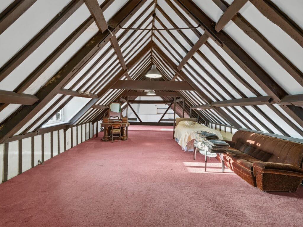 Spacious vaulted attic bedroom with exposed timber trusses