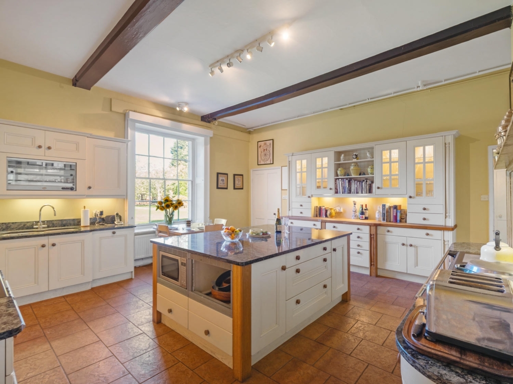 Farmhouse kitchen with central island, granite worktops and bespoke cabinets at Loddon Hall