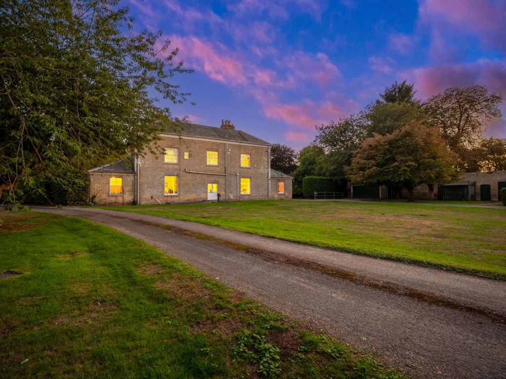 Rear of Loddon Hall at dusk with driveway and lawn, Georgian country house in Norfolk