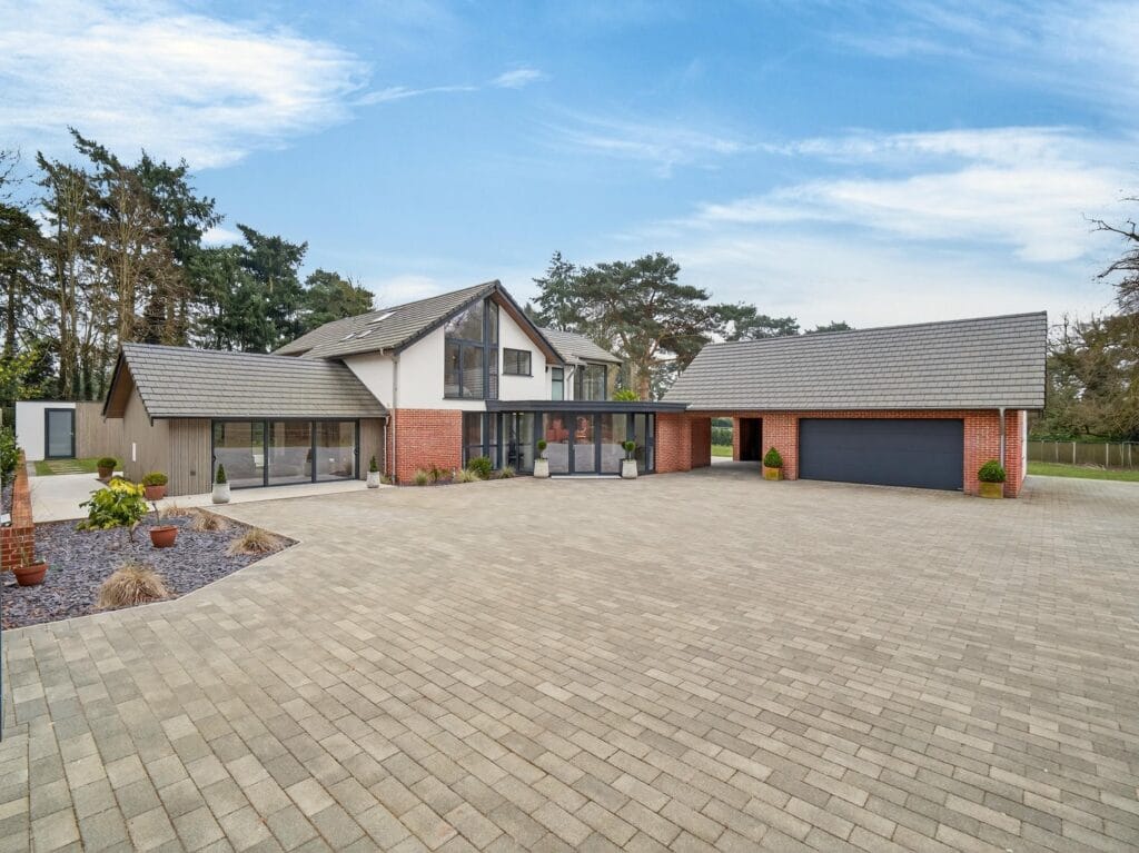 Luxury detached contemporary home with large block paved driveway, double garage and landscaped front approach.