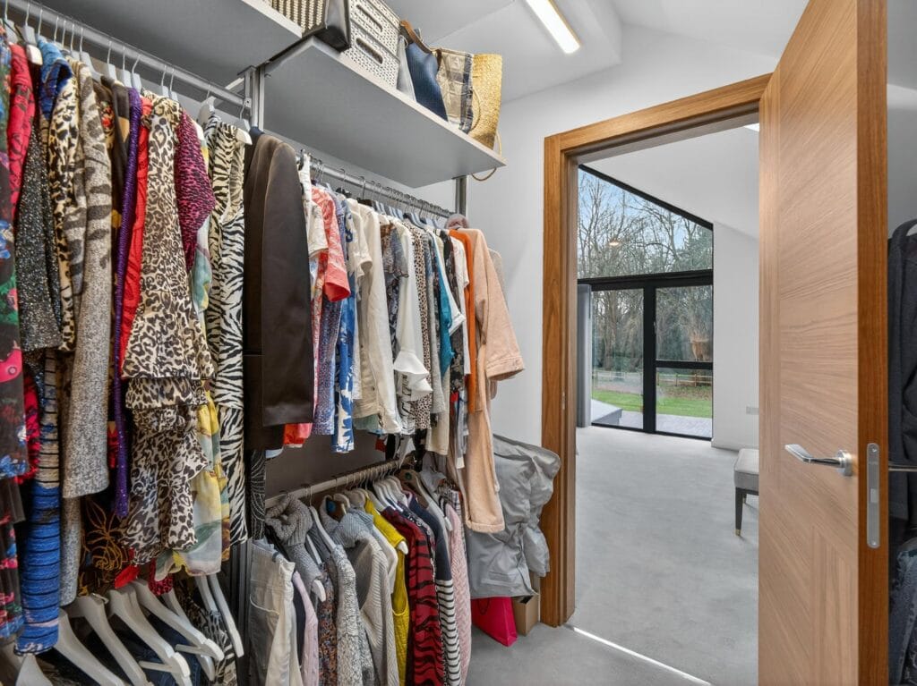 Walk-in wardrobe dressing room connected to the principal bedroom with built-in clothing storage and shelving.