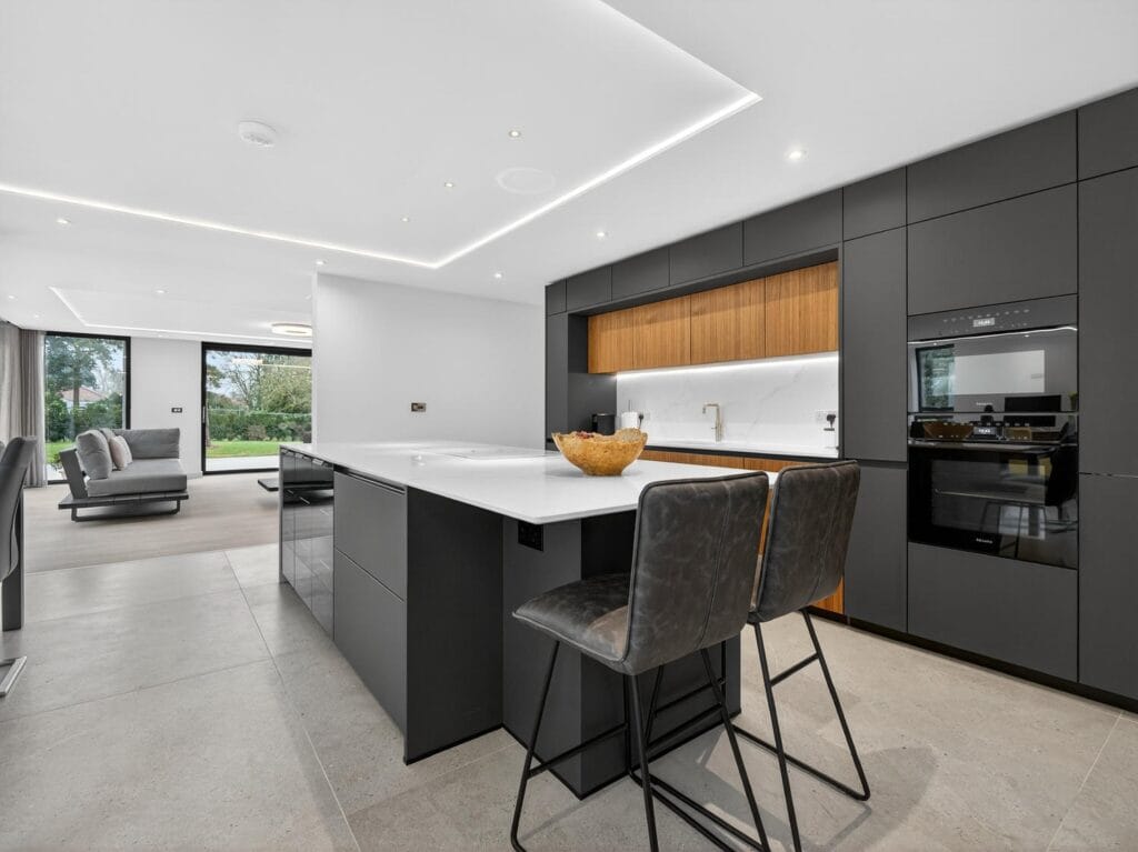 Contemporary luxury kitchen with large island, integrated appliances, handleless cabinets and open-plan living space
