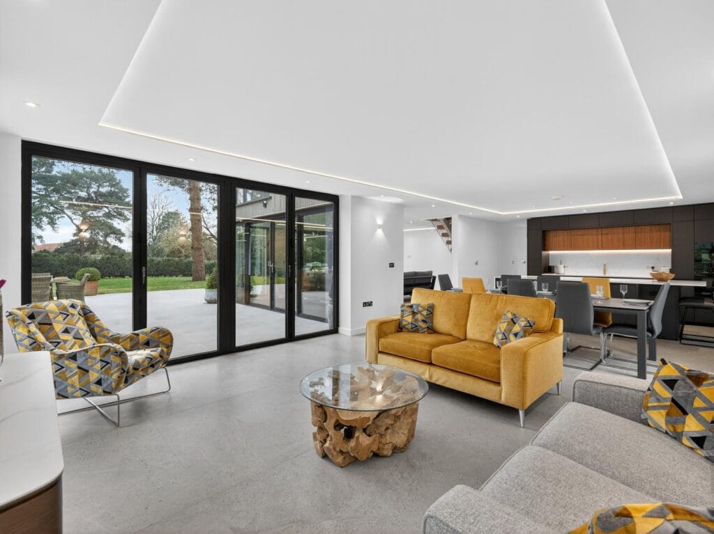 Modern open-plan living and dining area with large sliding doors to the garden patio and contemporary fitted kitchen.