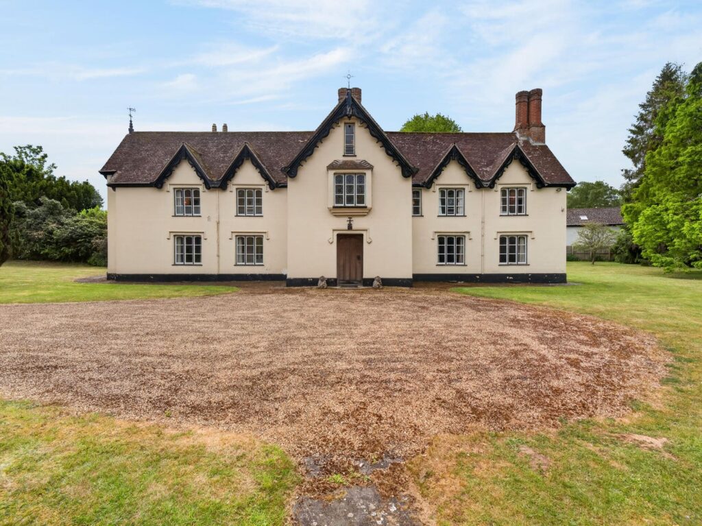 Front elevation of The Priory Suffolk showing symmetrical gables, stained glass window and gravel forecourt