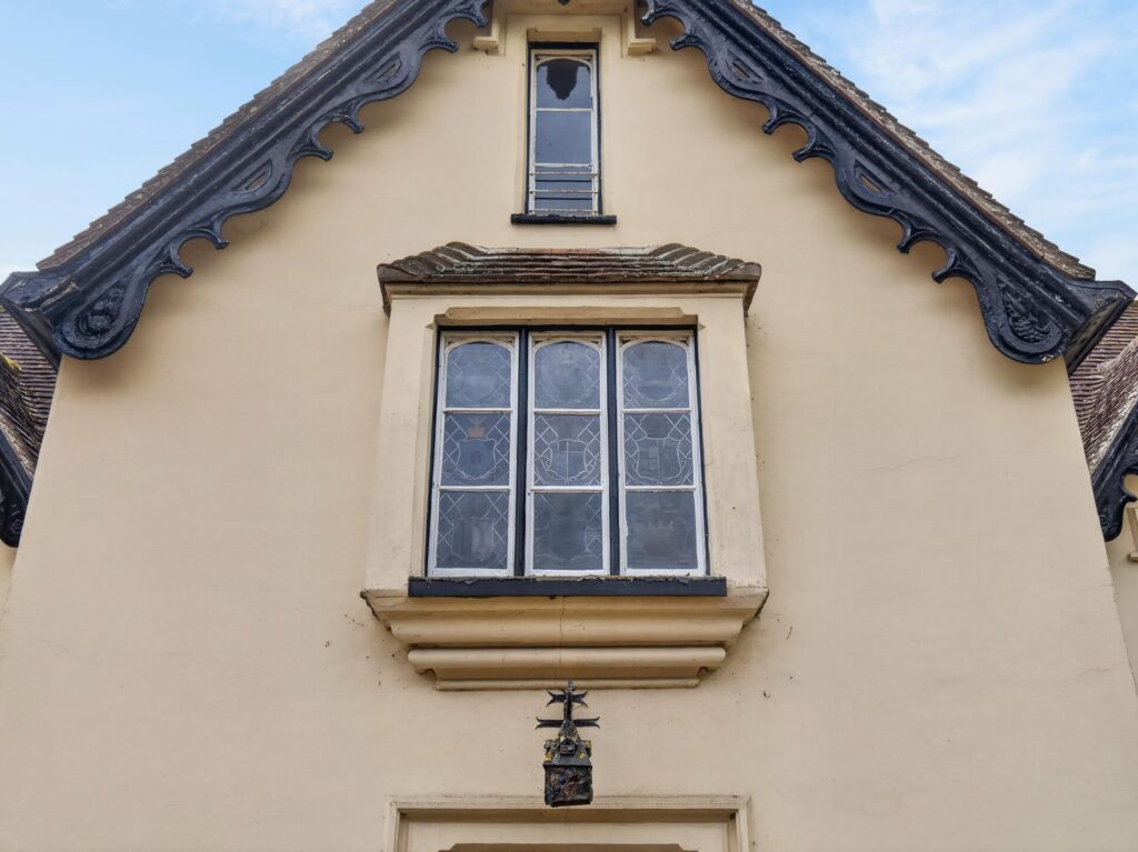 Decorative bargeboards and stained glass oriel window above the entrance to The Priory Suffolk