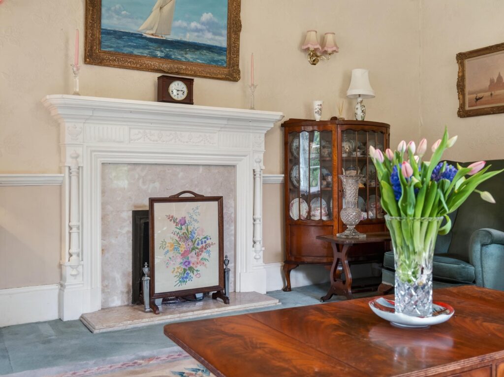 Carved fire surround with swag detail and fluted columns in the drawing room at The Priory Suffolk