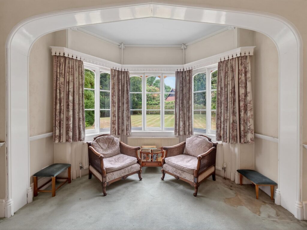 Bay window alcove at The Priory Suffolk overlooking the lawn through arched architrave
