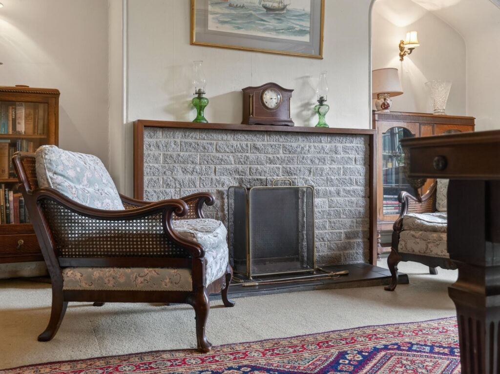 Brick fireplace and timber surround in the library at The Priory Suffolk