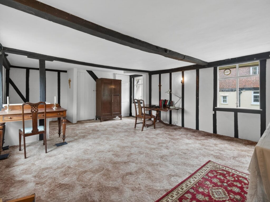 Bedroom at The Priory Suffolk with exposed timber frame, vertical studs, diagonal braces and ceiling beams