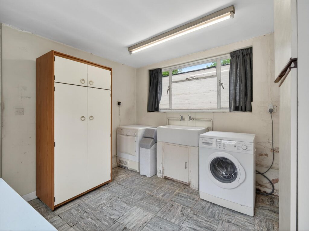 Utility room at The Priory Suffolk with Belfast sink, plumbing for laundry appliances and rear window