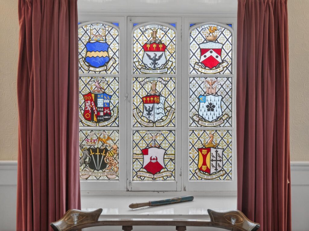 Nine heraldic crests of former owners of The Priory Suffolk in stained glass on the upstairs landing window