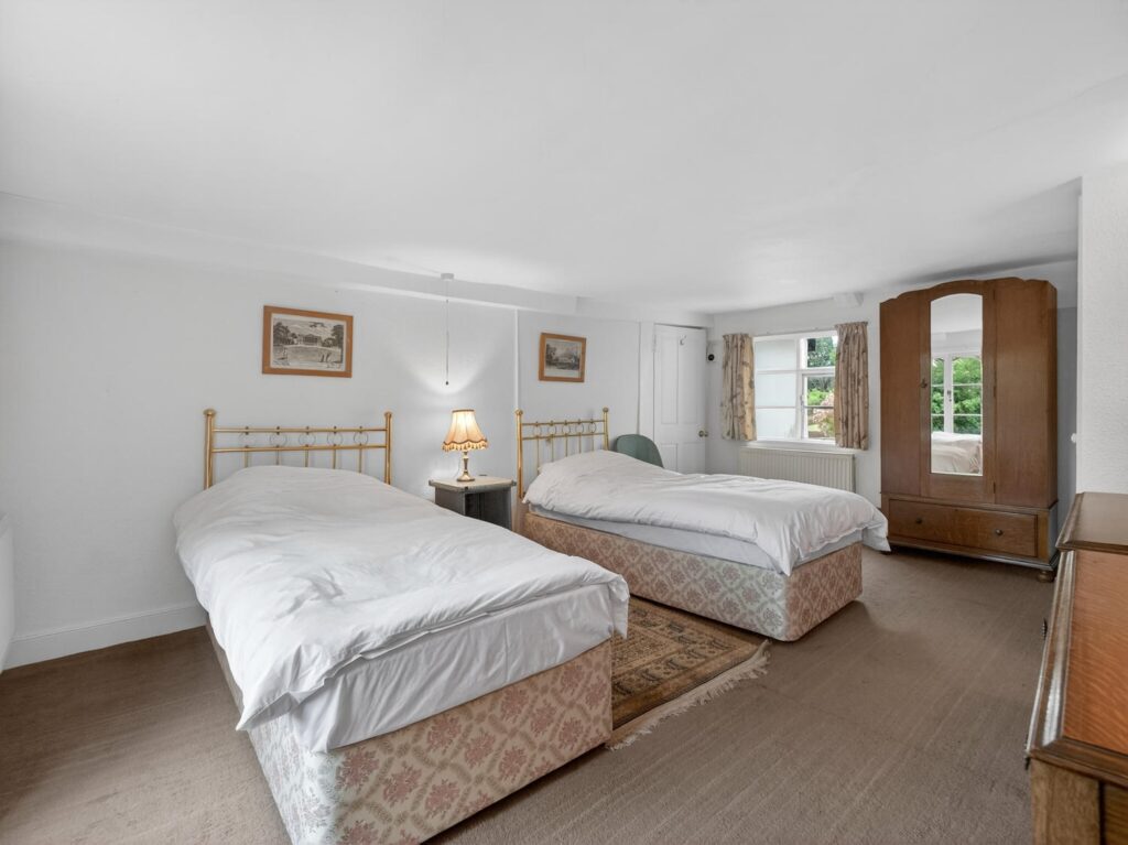 Twin bedroom at The Priory Suffolk with rear-facing window overlooking the garden
