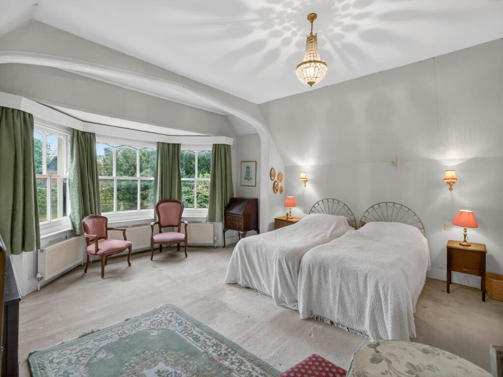 Principal bedroom with ensuite at The Priory Suffolk, curved bay window and pitched ceiling