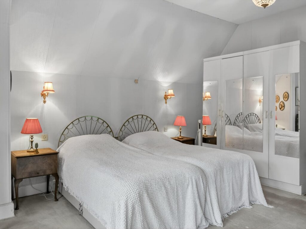 Principal bedroom at The Priory Suffolk shown from the opposite end with pitched ceiling