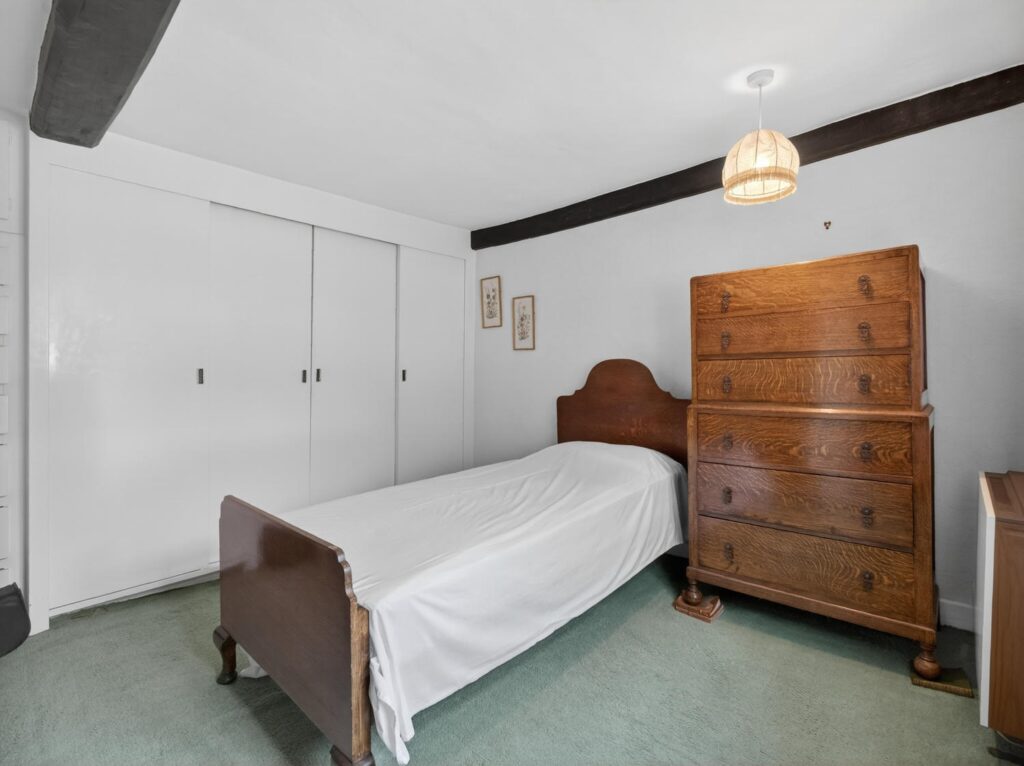 Double bedroom at The Priory Suffolk with exposed ceiling beams and fitted wardrobes