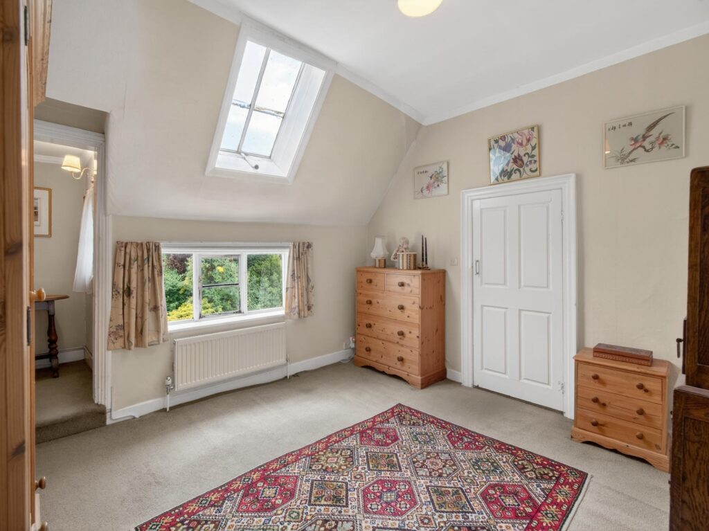 Double bedroom currently used as a dressing room at The Priory Suffolk, with pitched ceiling and skylight